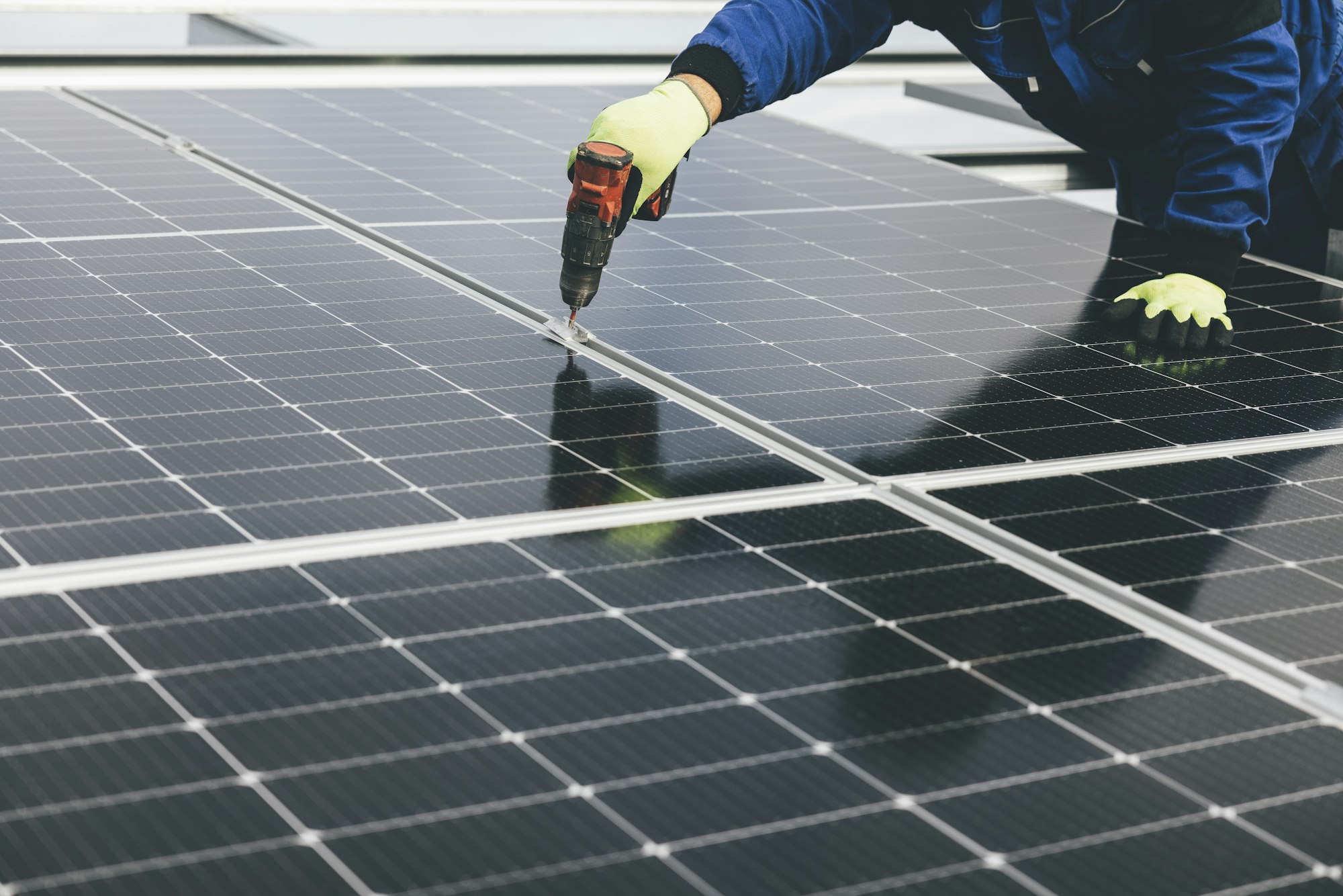 A technician working on the mid-clamps of an installed solar array